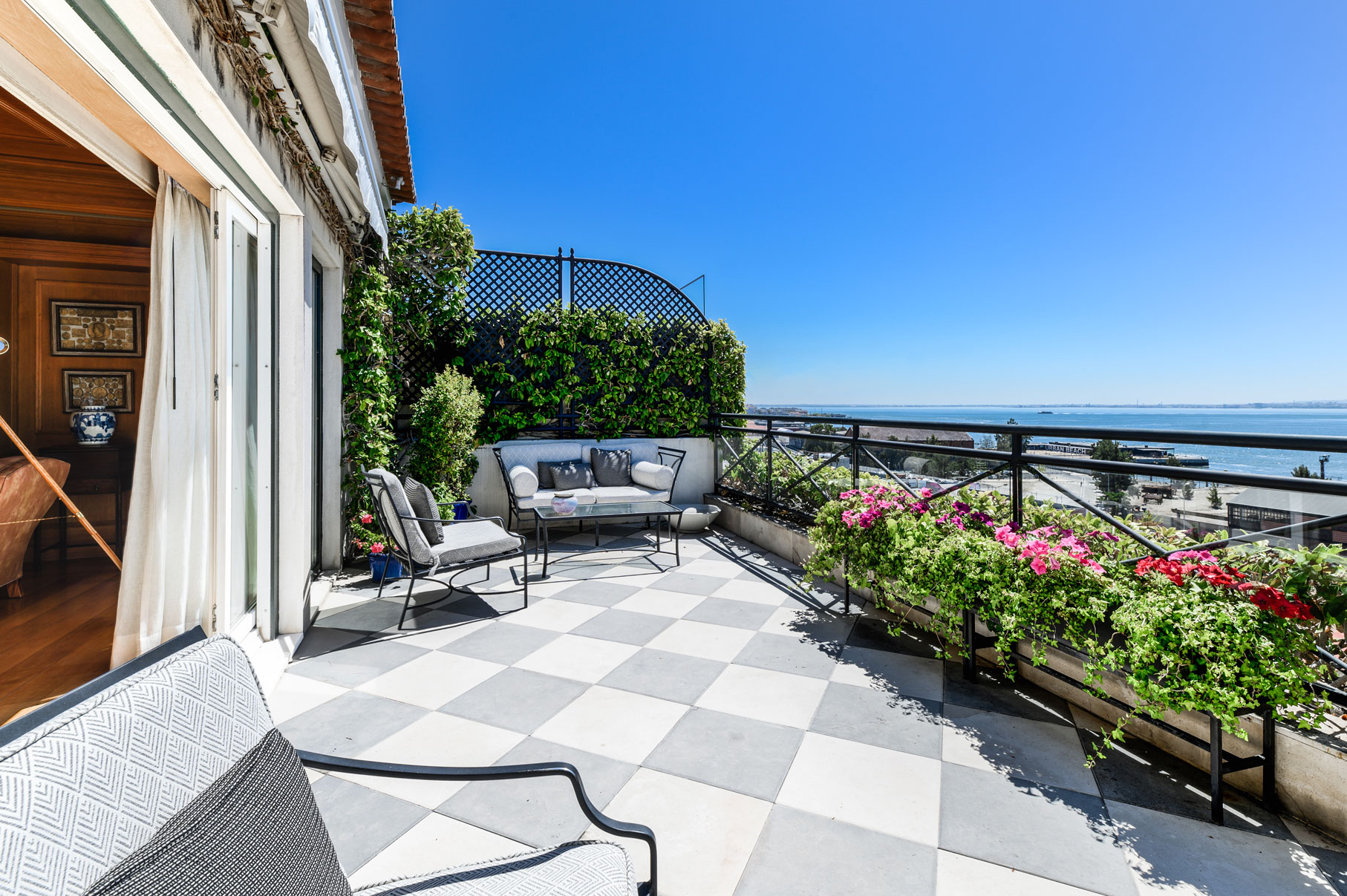 a patio with chairs and flowers on a balcony
