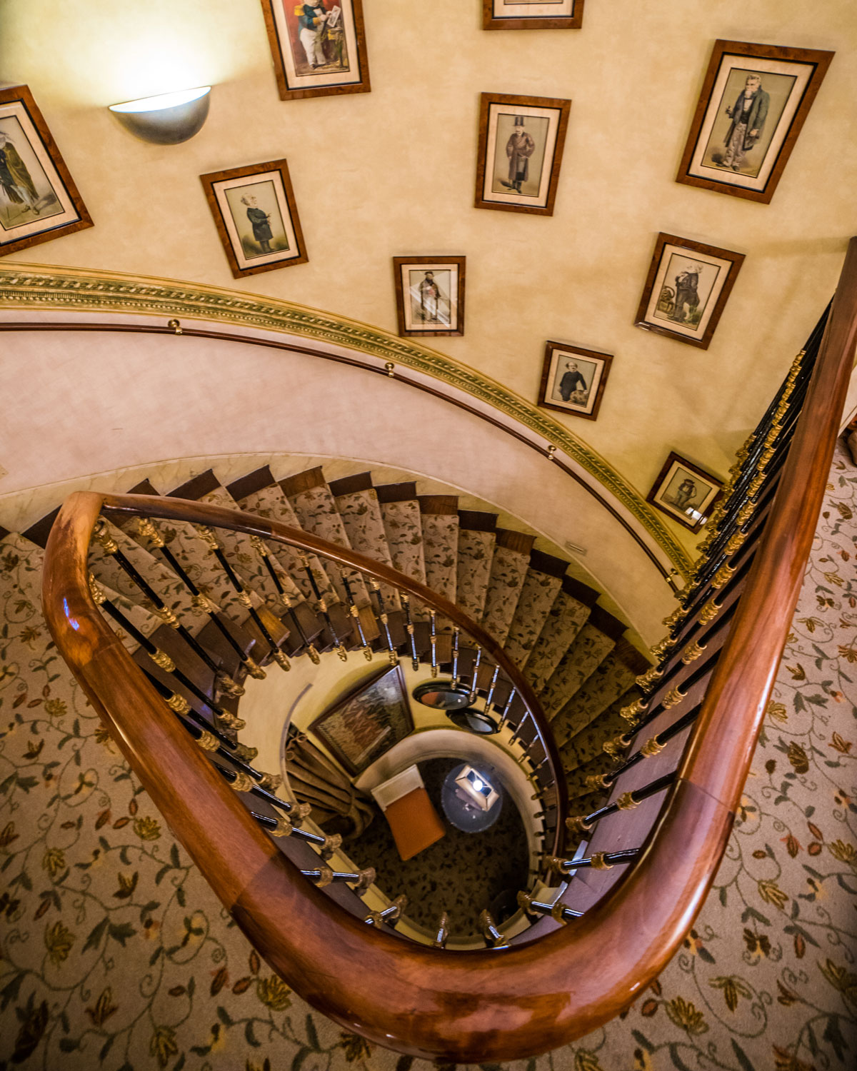 a spiral staircase with pictures on the ceiling
