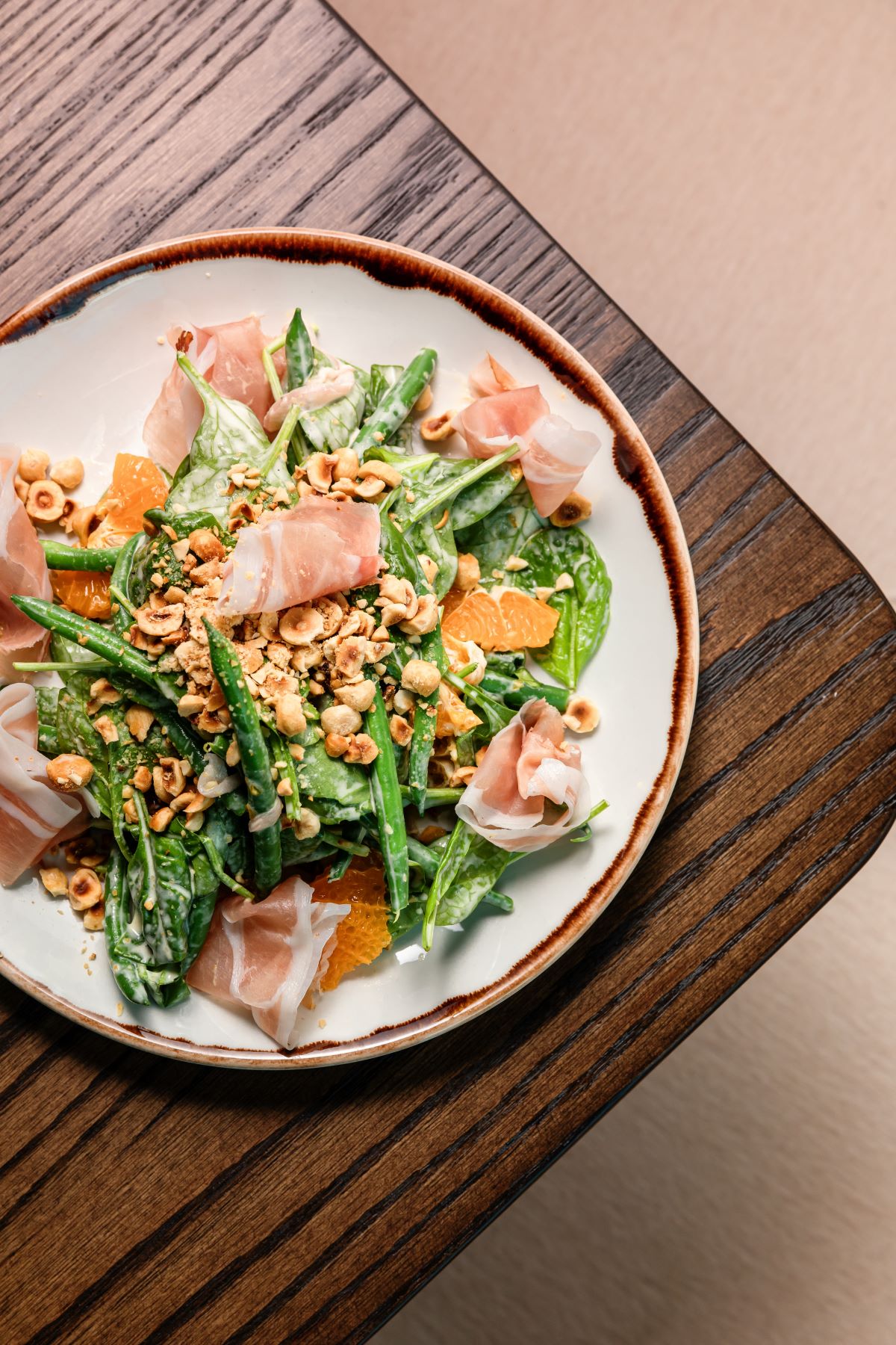 a plate of salad with nuts and meat
