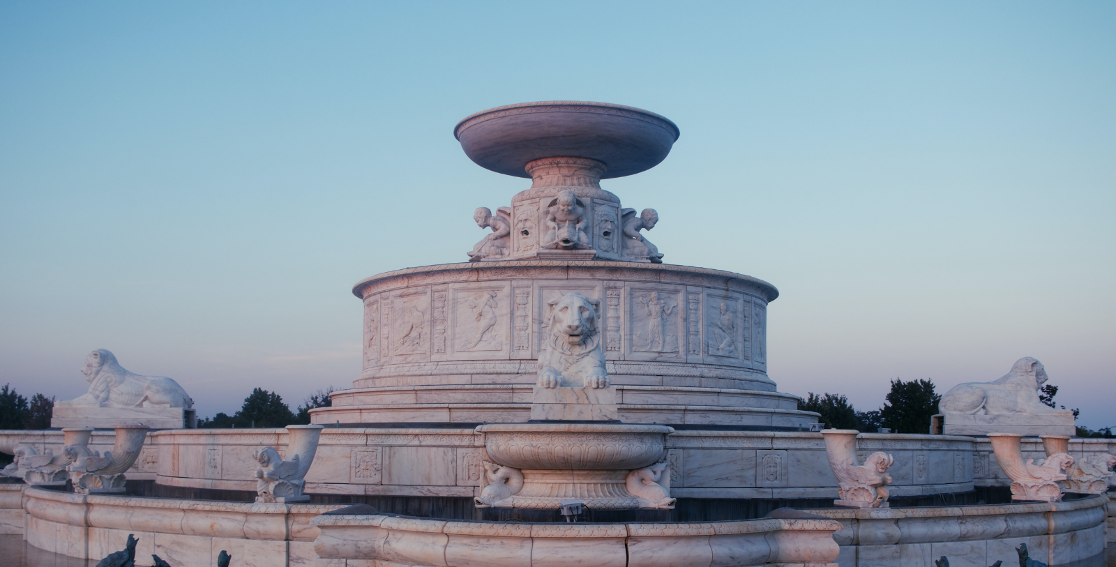 a large white fountain with lions statues