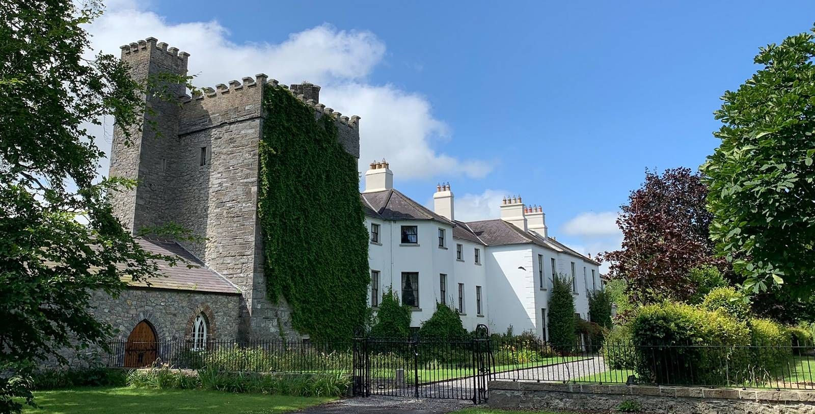 a building with a stone tower and a fence