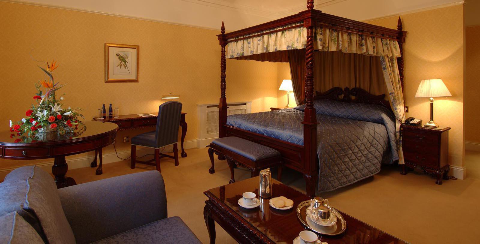 a room with a four poster bed and a table