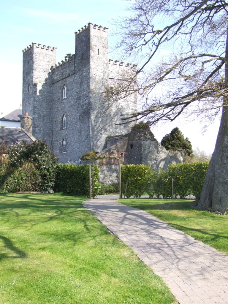a stone castle with a path and grass