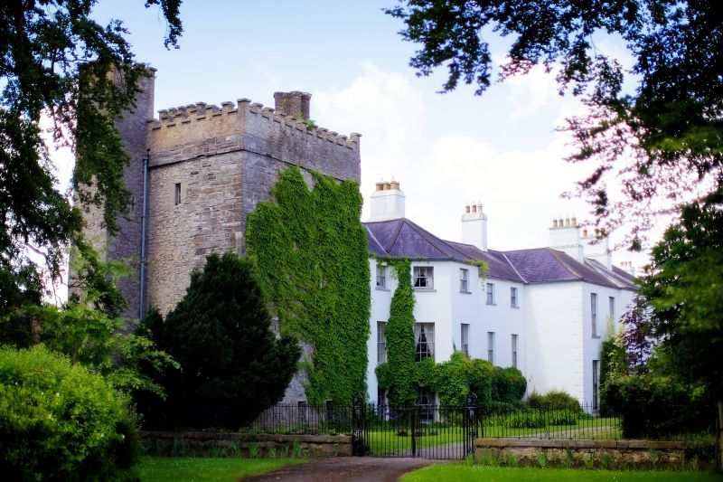 a white building with a stone tower and a gate