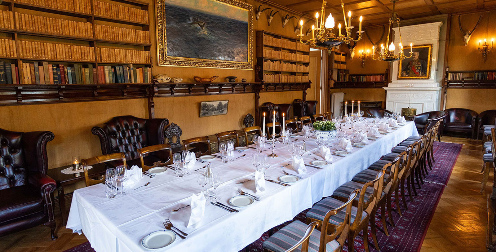 a long table with white tablecloths and candles