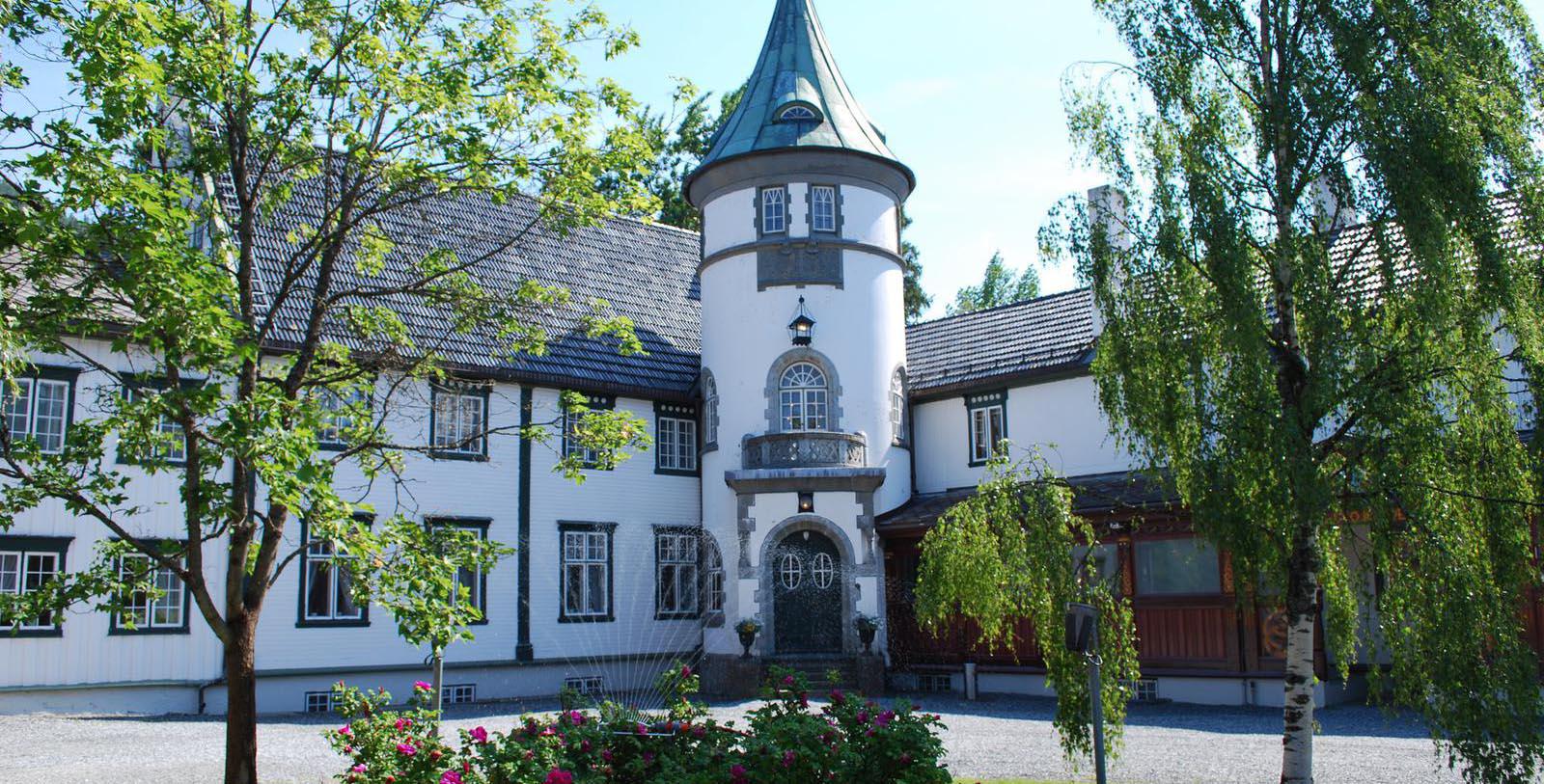 a large white and grey building with a round tower