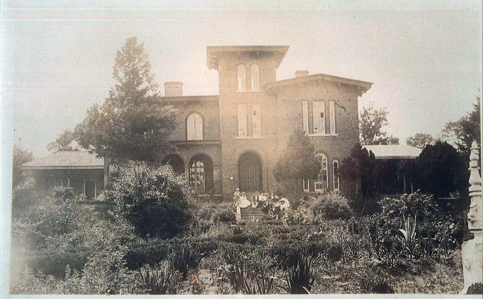 a large brick building with a group of people outside