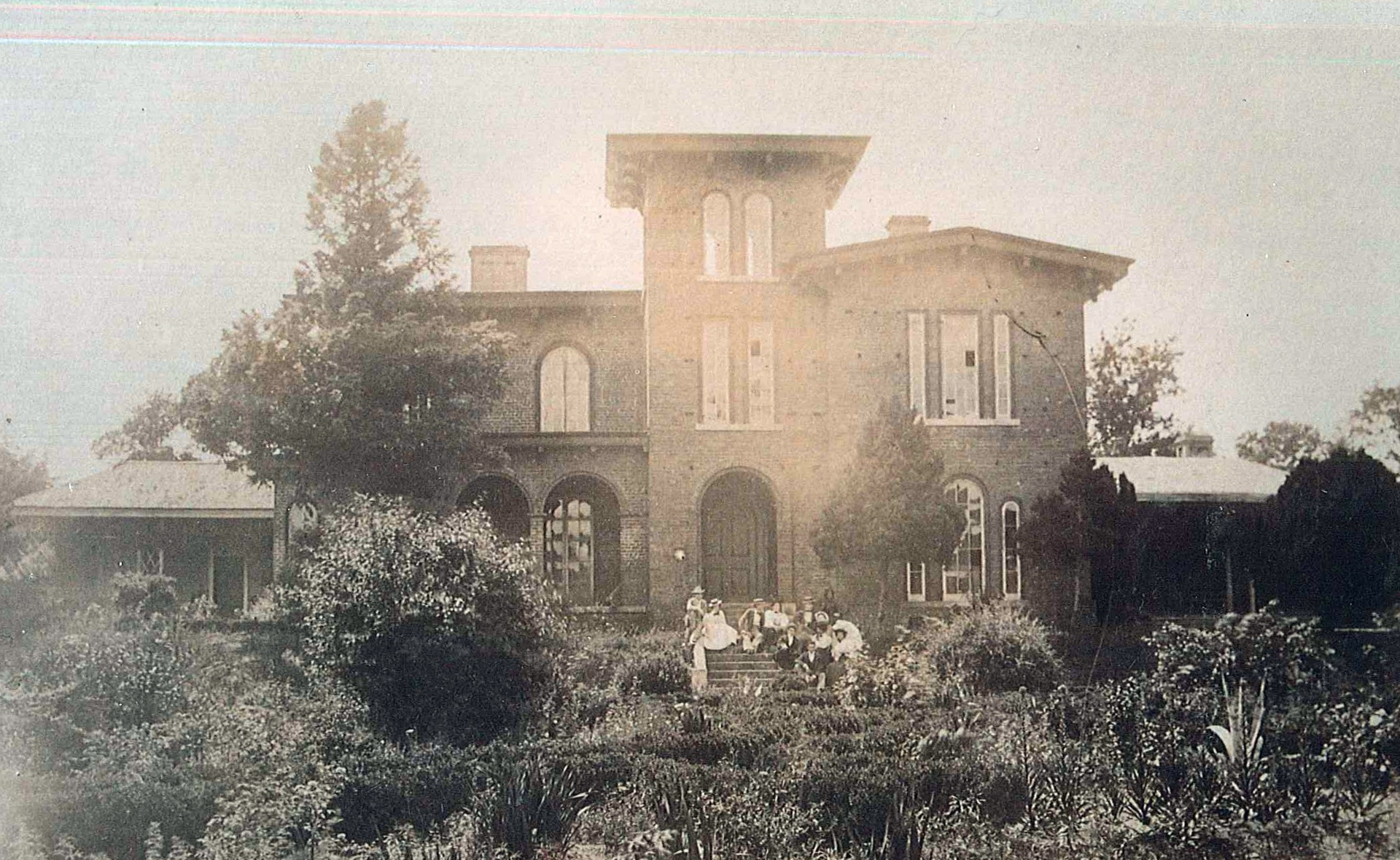 a group of people outside a brick house