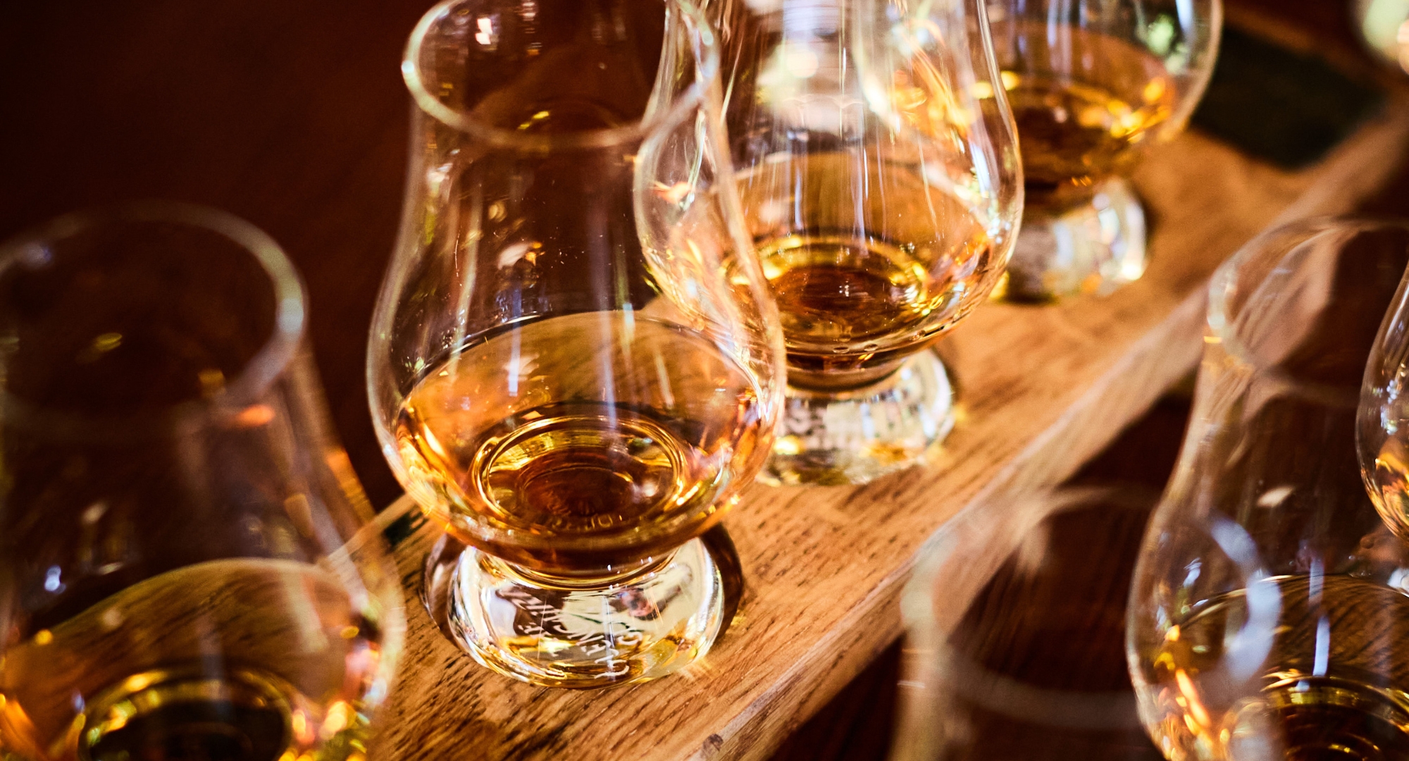a group of glasses with amber liquid