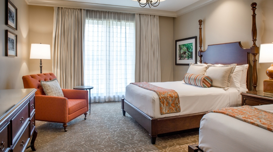 a room with two beds and a chandelier