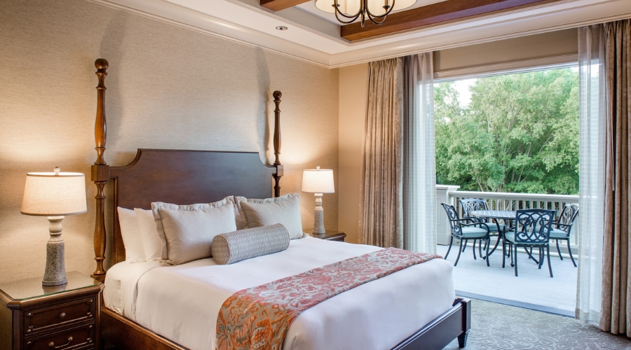 a bedroom with a large bed and a glass door