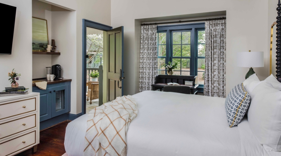a bed in a room with a piano and a window
