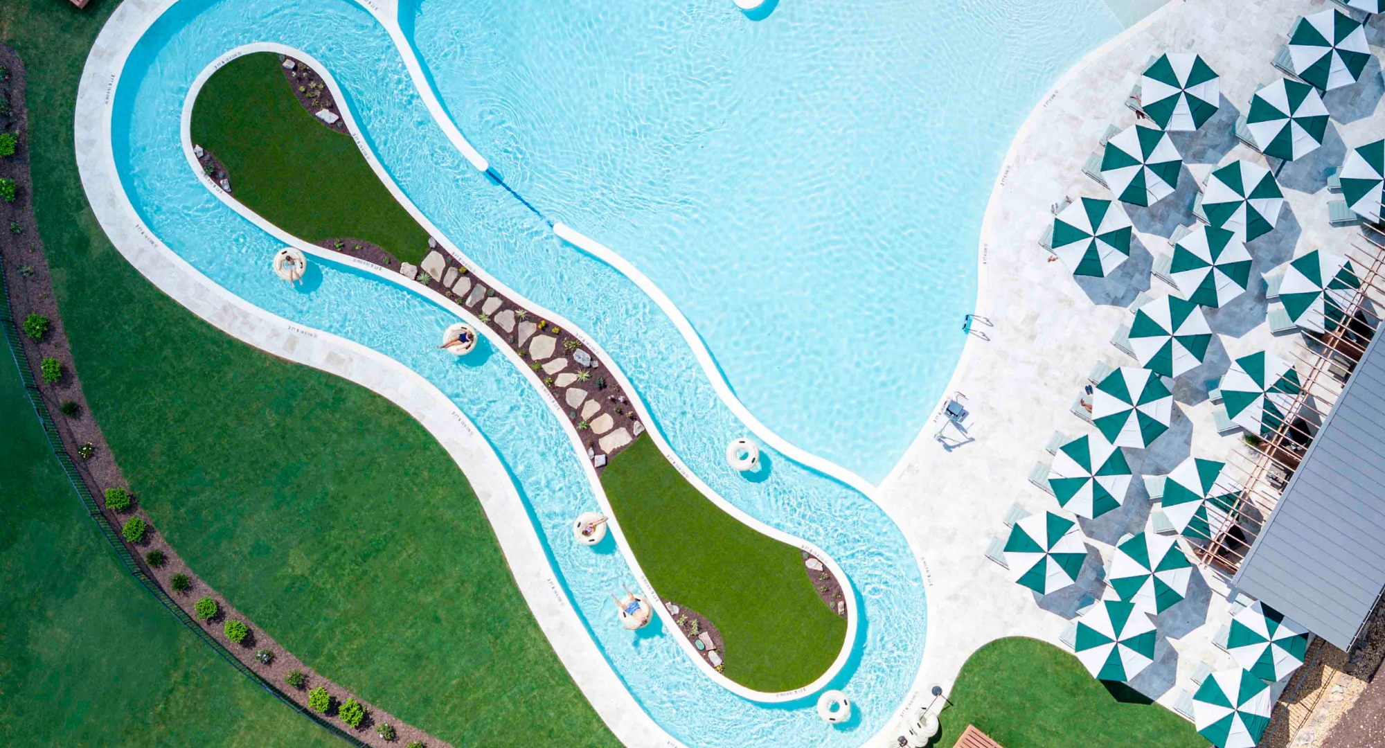 a pool with grass and grass and people on tubes