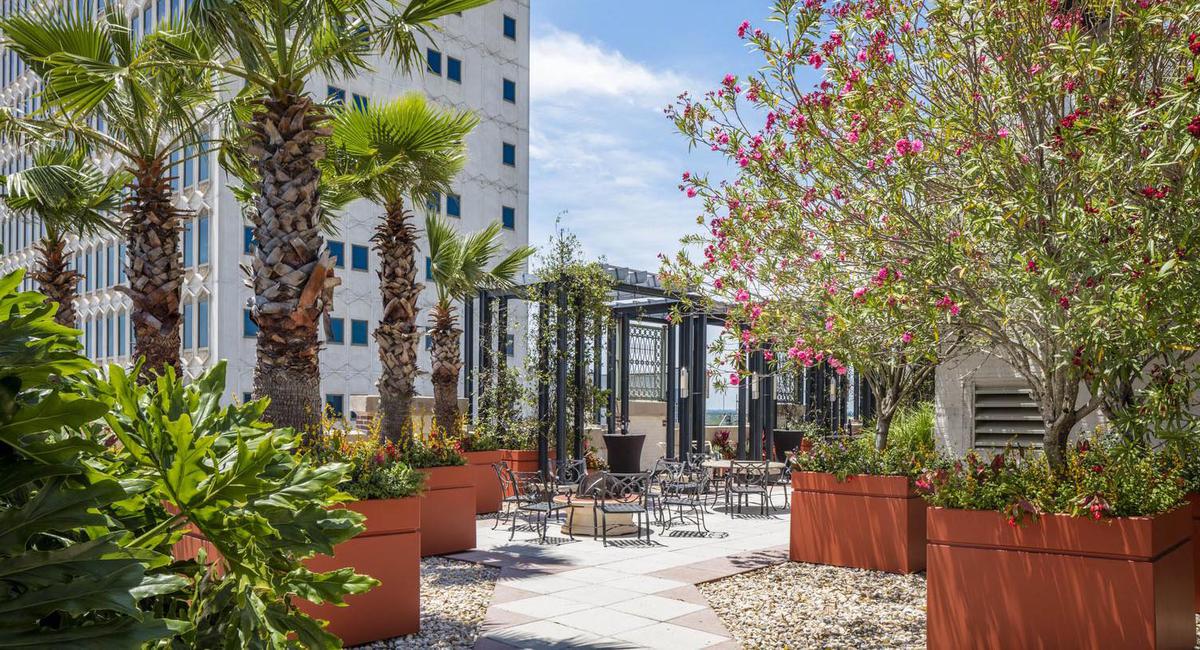 a patio with tables and chairs and trees