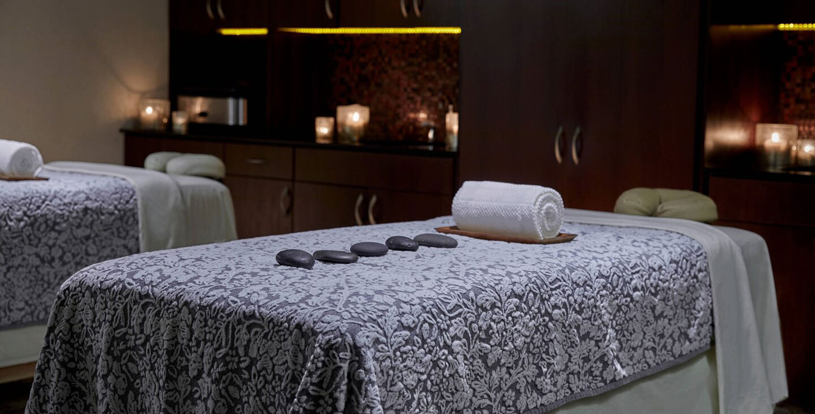 a massage table with a roll of towels and stones