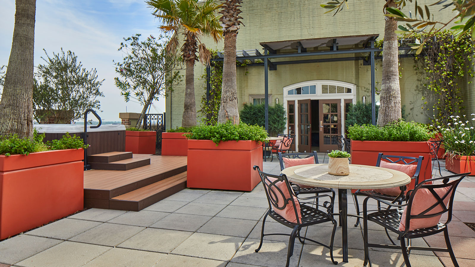 a patio with a table and chairs and plants