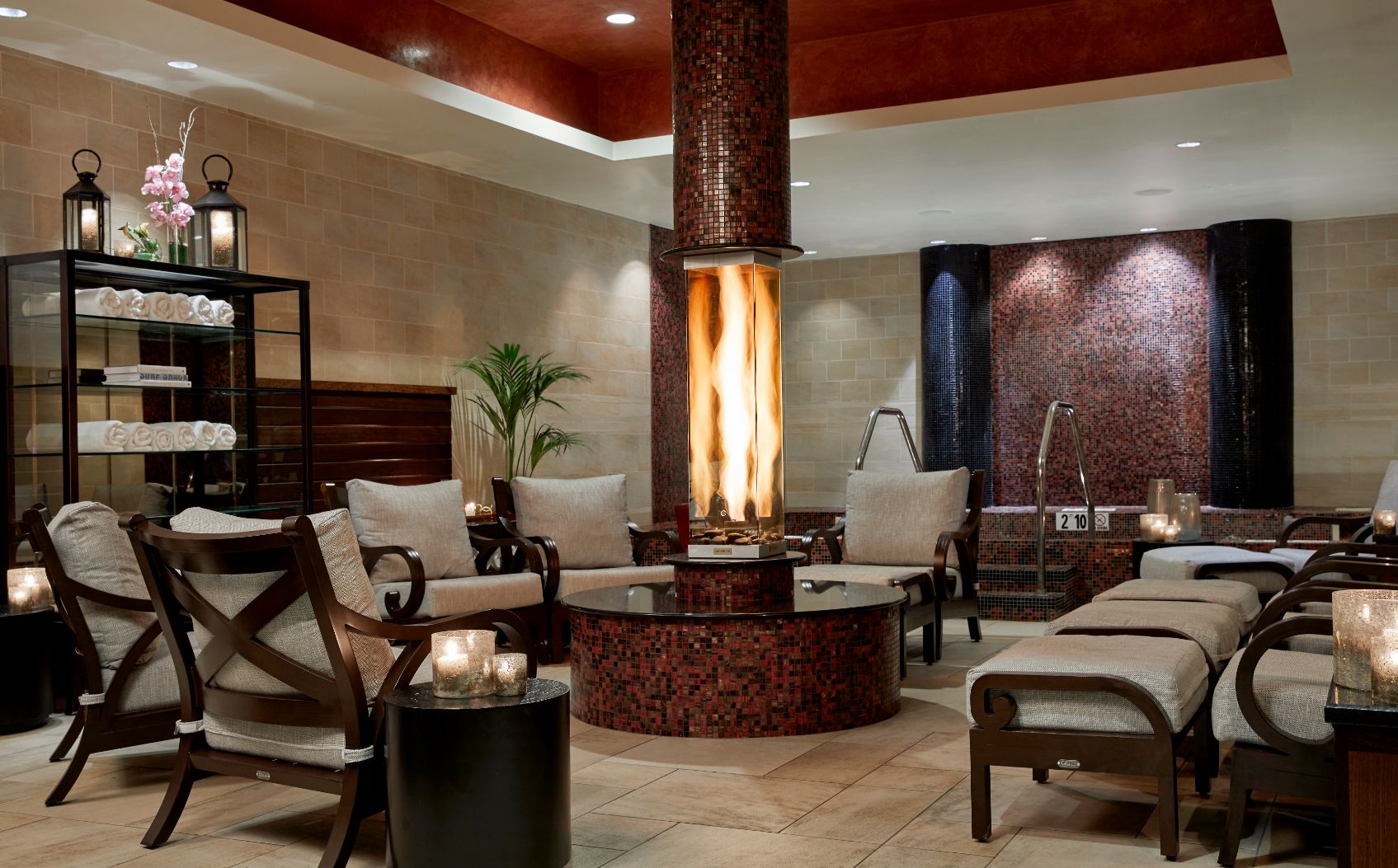 a room with a hot tub and a fire in the middle