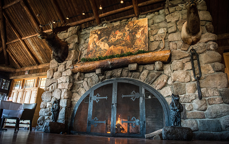 a fireplace with a picture of a deer head and a painting on the wall
