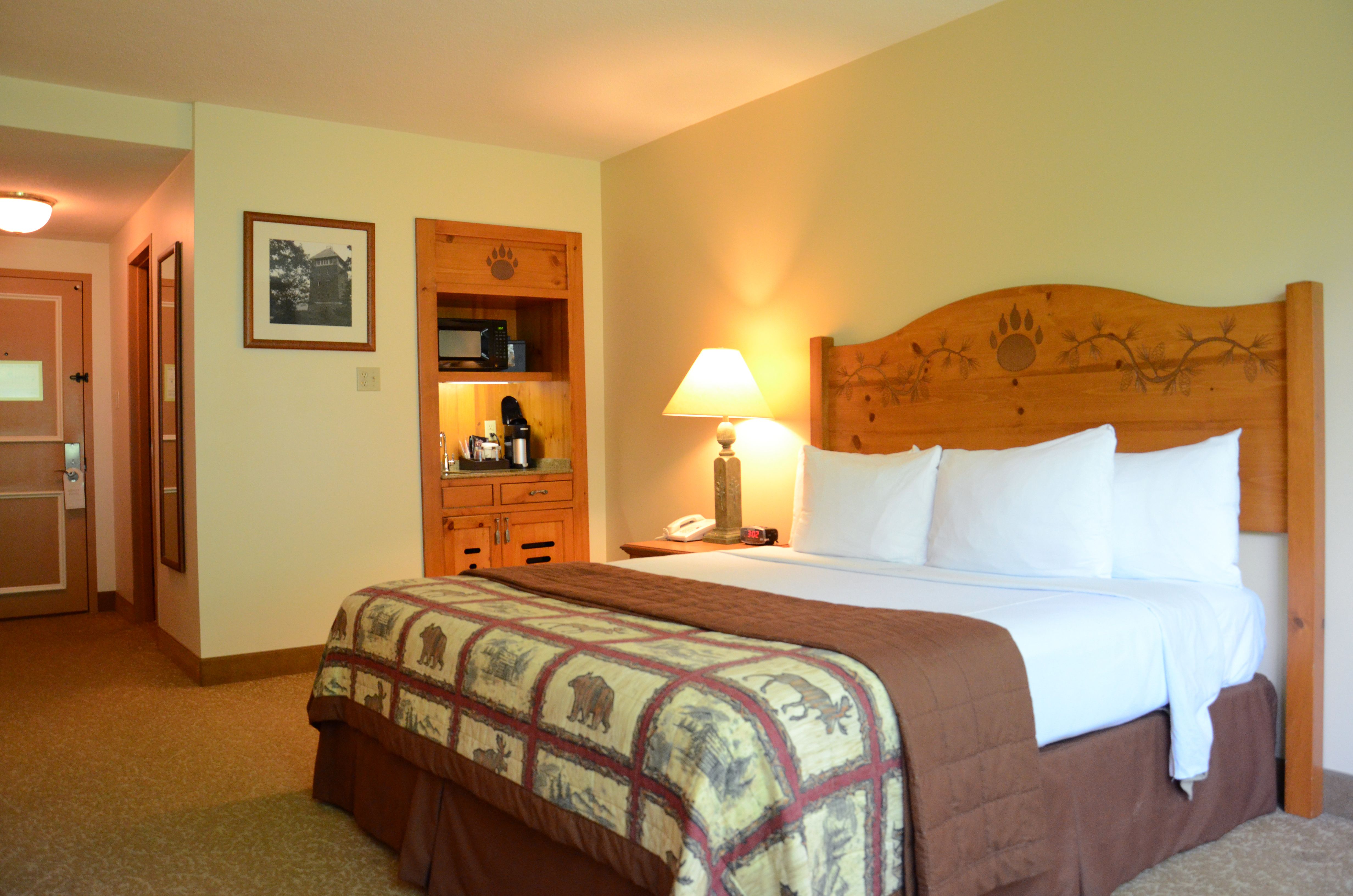 a bed with a wooden headboard and lamps in a room