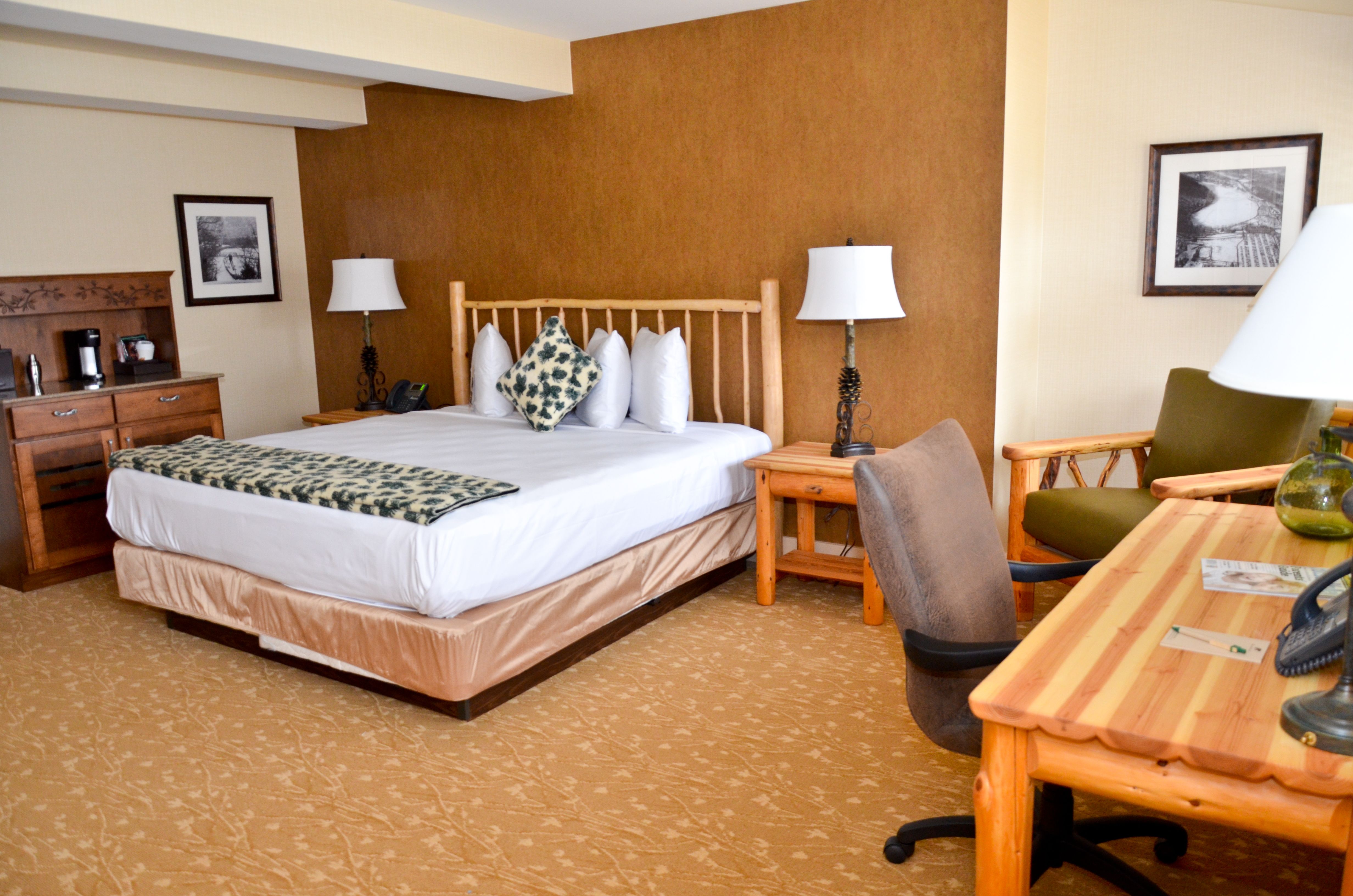 a bed with a wood headboard and a desk in a hotel room