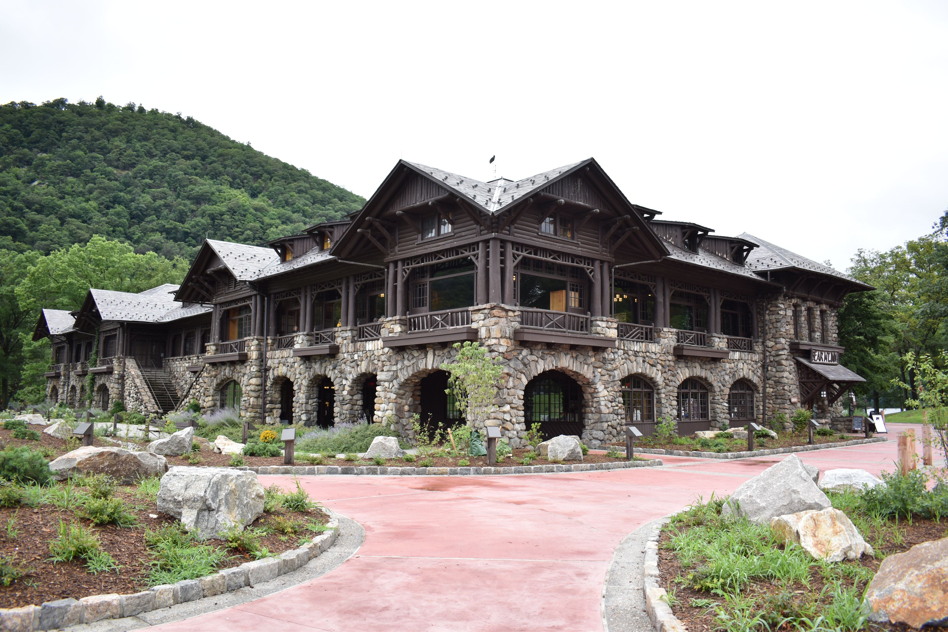 a building with a stone walkway and trees in the background