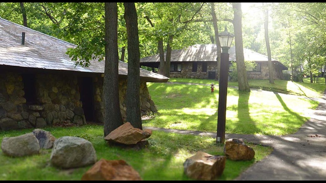 a stone building with trees and a lamp post