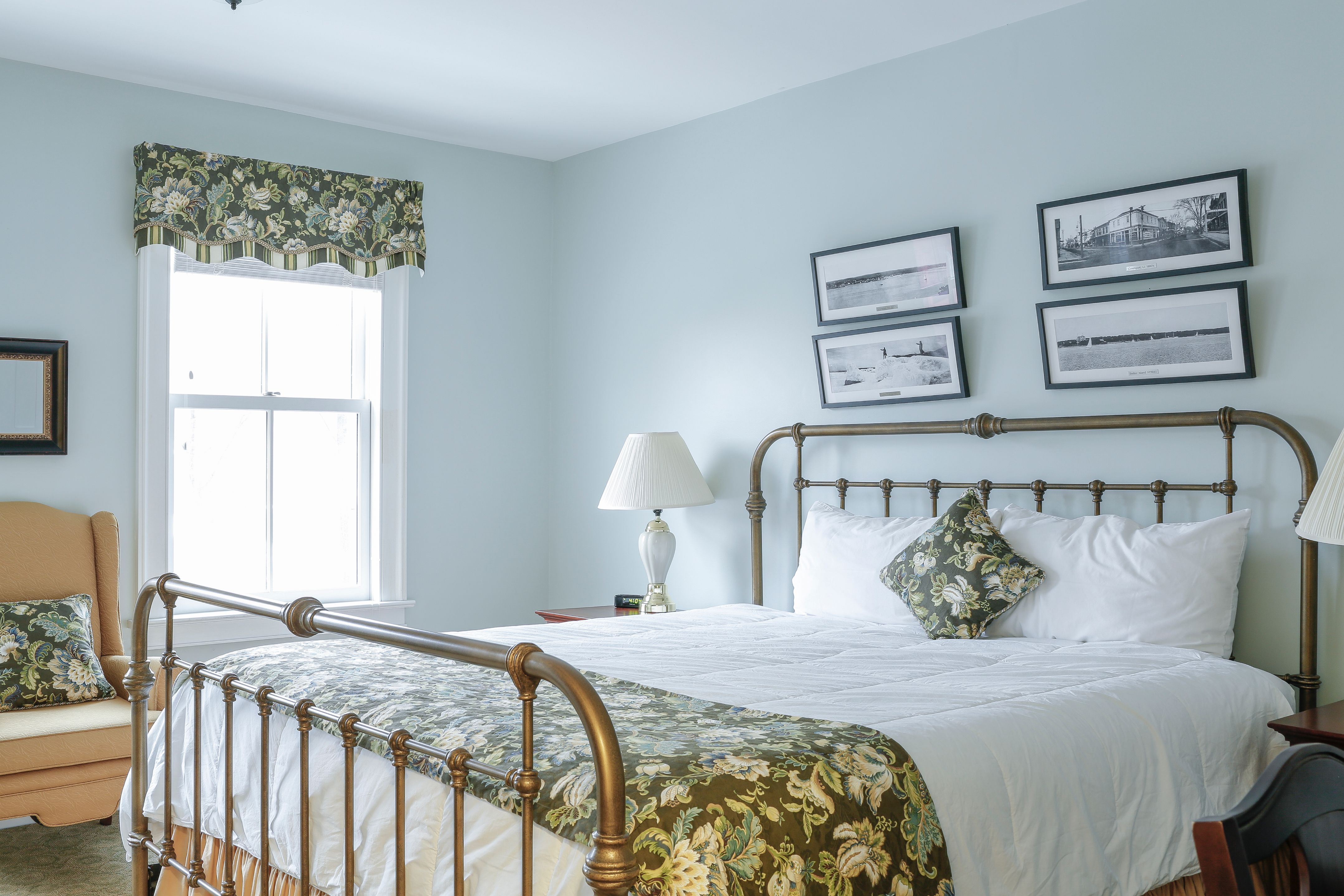 a bed with a lamp and picture frames on the wall