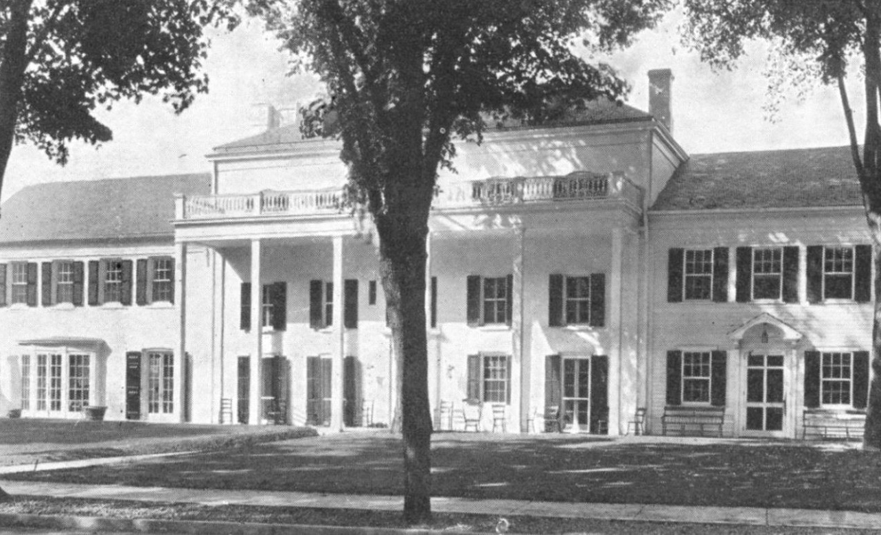 a large white building with a large tree