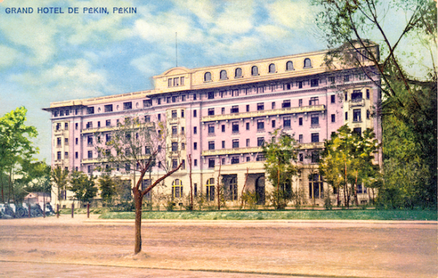 a large building with trees and a road