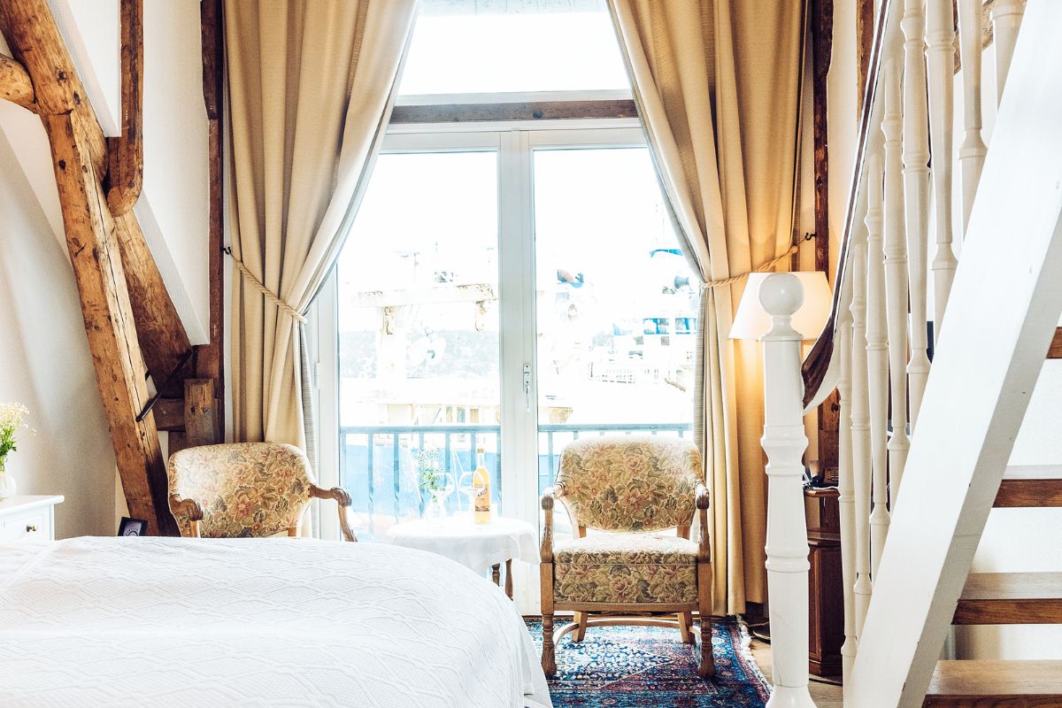 a room with a bed and chairs