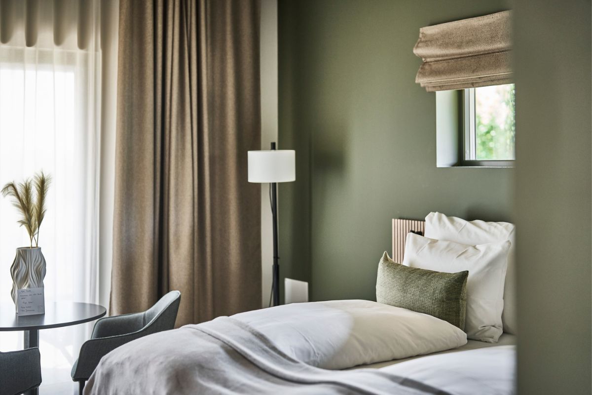 a bed with pillows and a lamp in a room