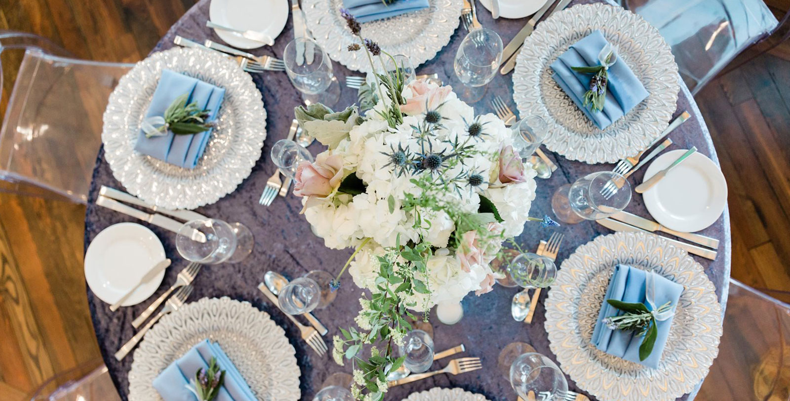 a table set with plates and glasses and a bouquet of flowers