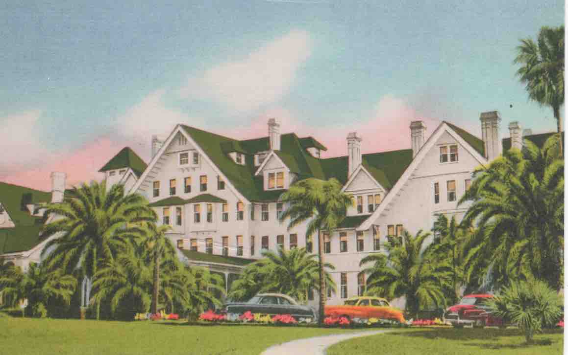 a large white building with palm trees