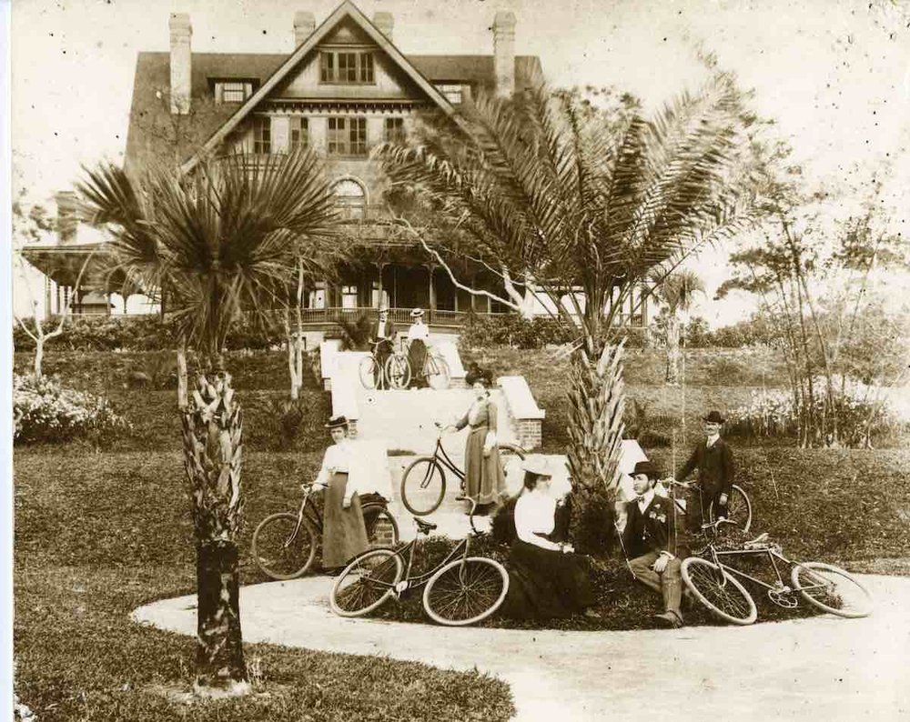 a group of people sitting on bicycles in front of a house