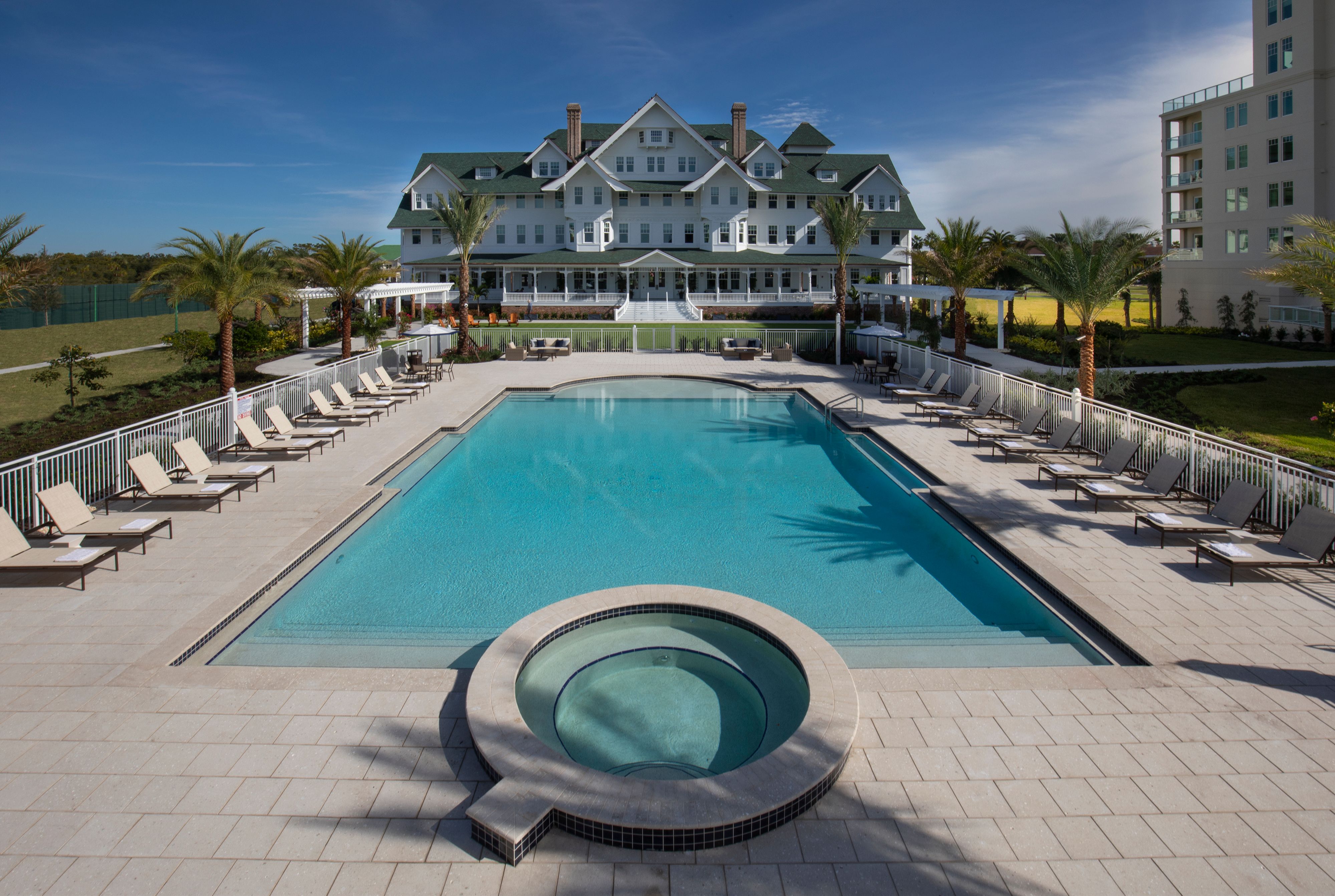 a pool with a hot tub and palm trees