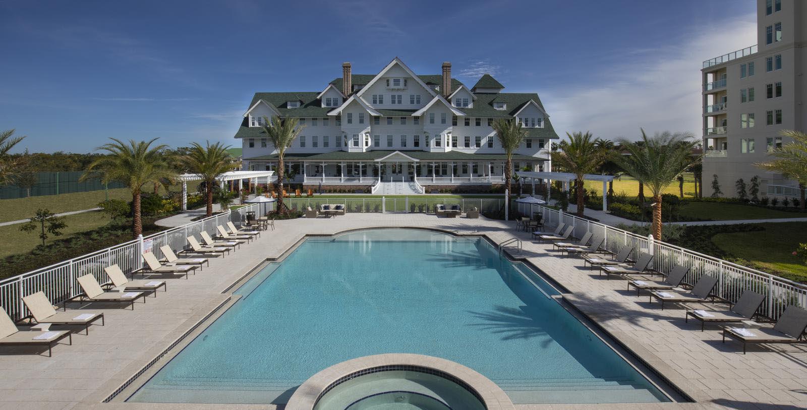a large white building with a pool and a jacuzzi