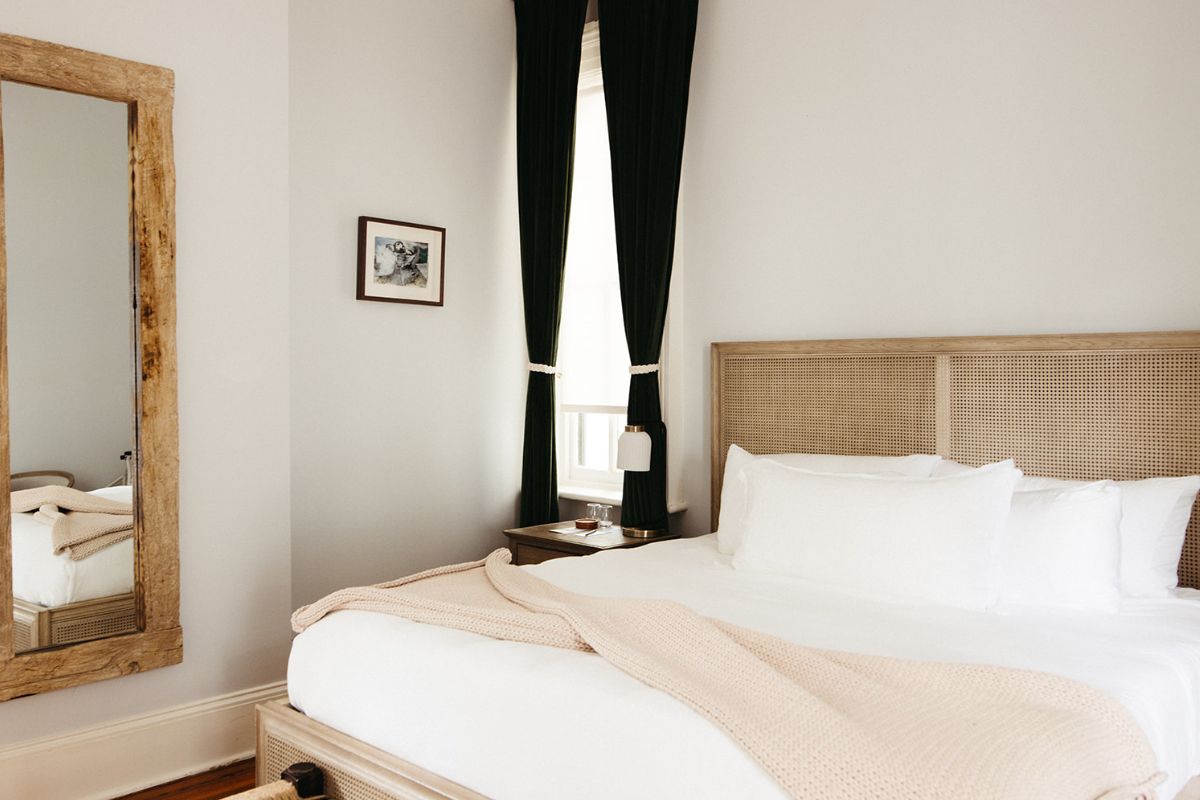 a bed with a blanket and a black curtain