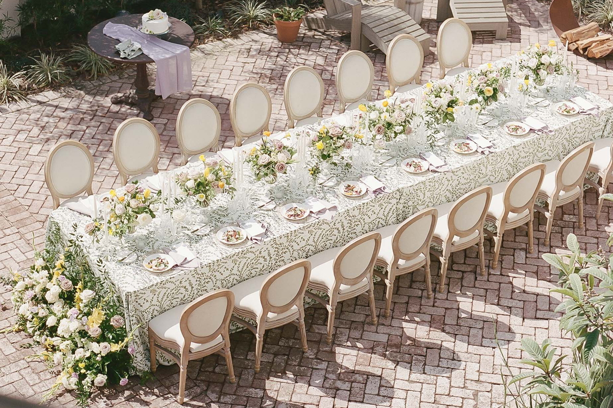 a long table with chairs and flowers