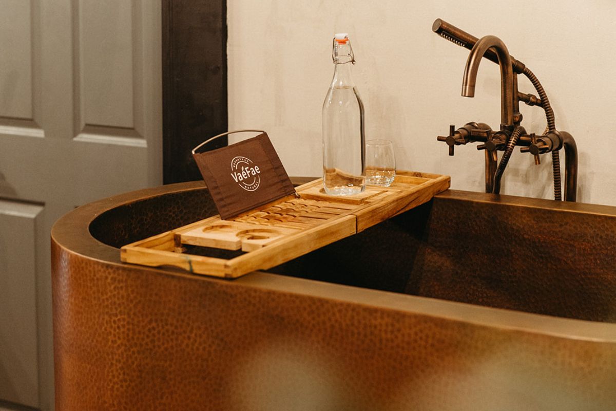 a wooden tray with glasses and a bottle on it
