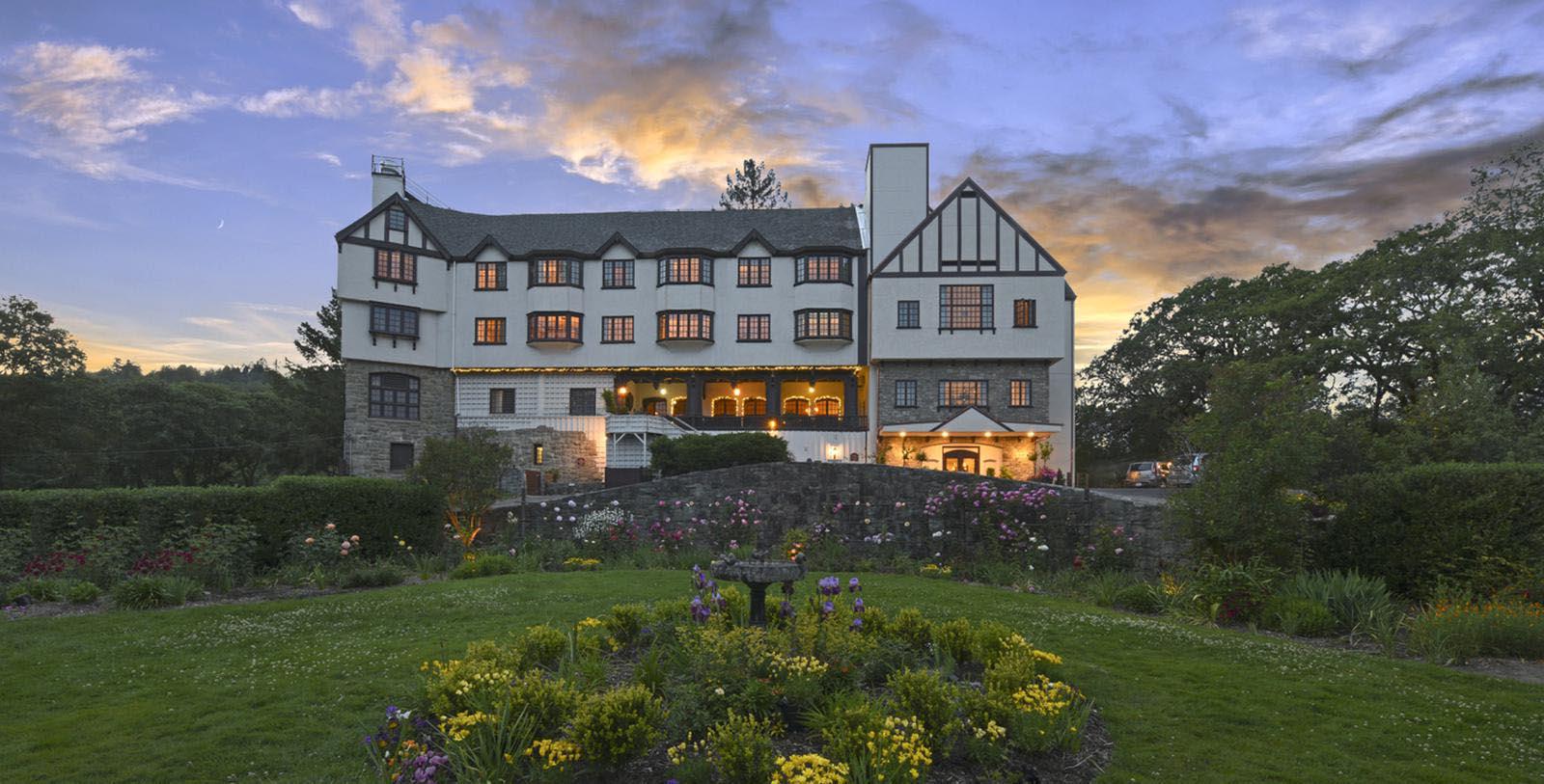 a large building with a garden and a stone wall