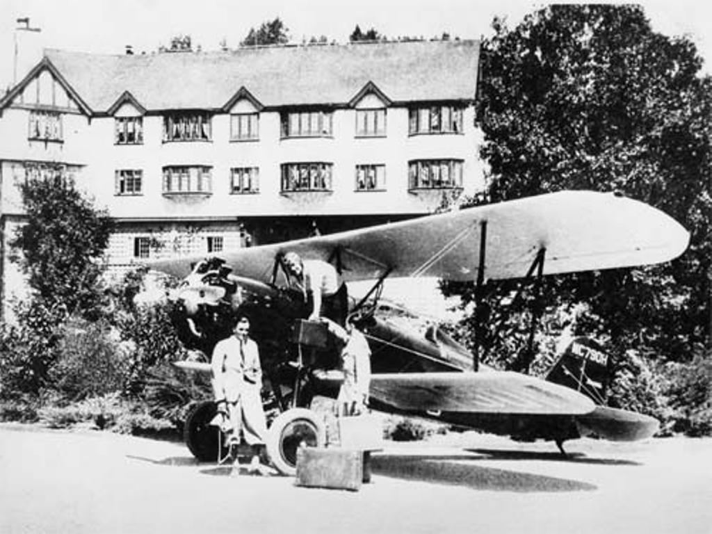a group of men standing next to an airplane