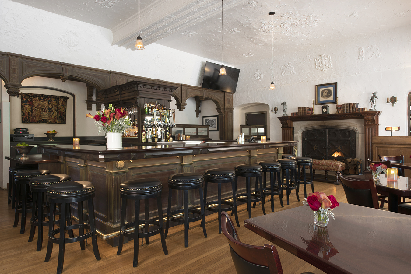 a bar with stools and a fireplace