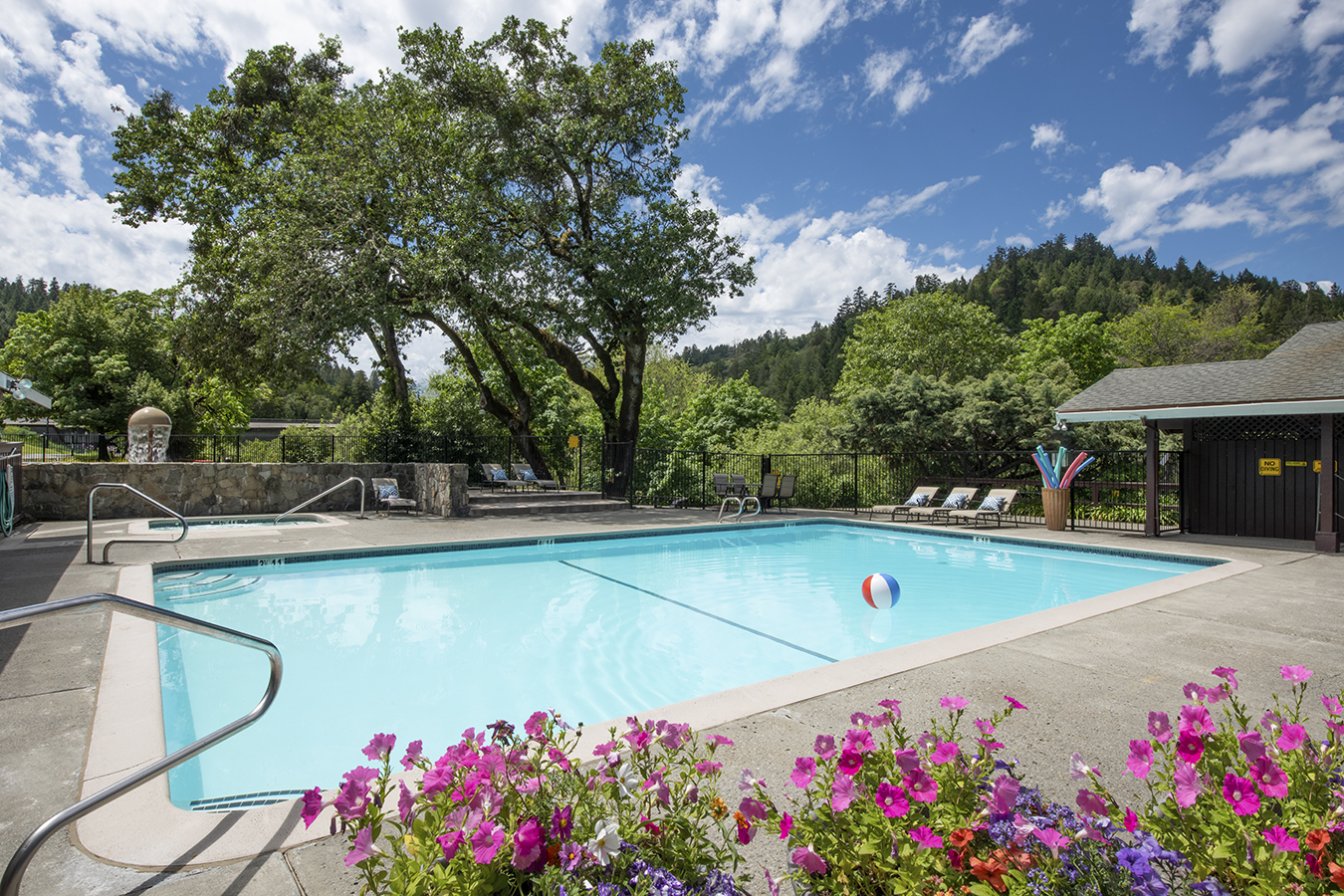 a pool with chairs and a ball in it