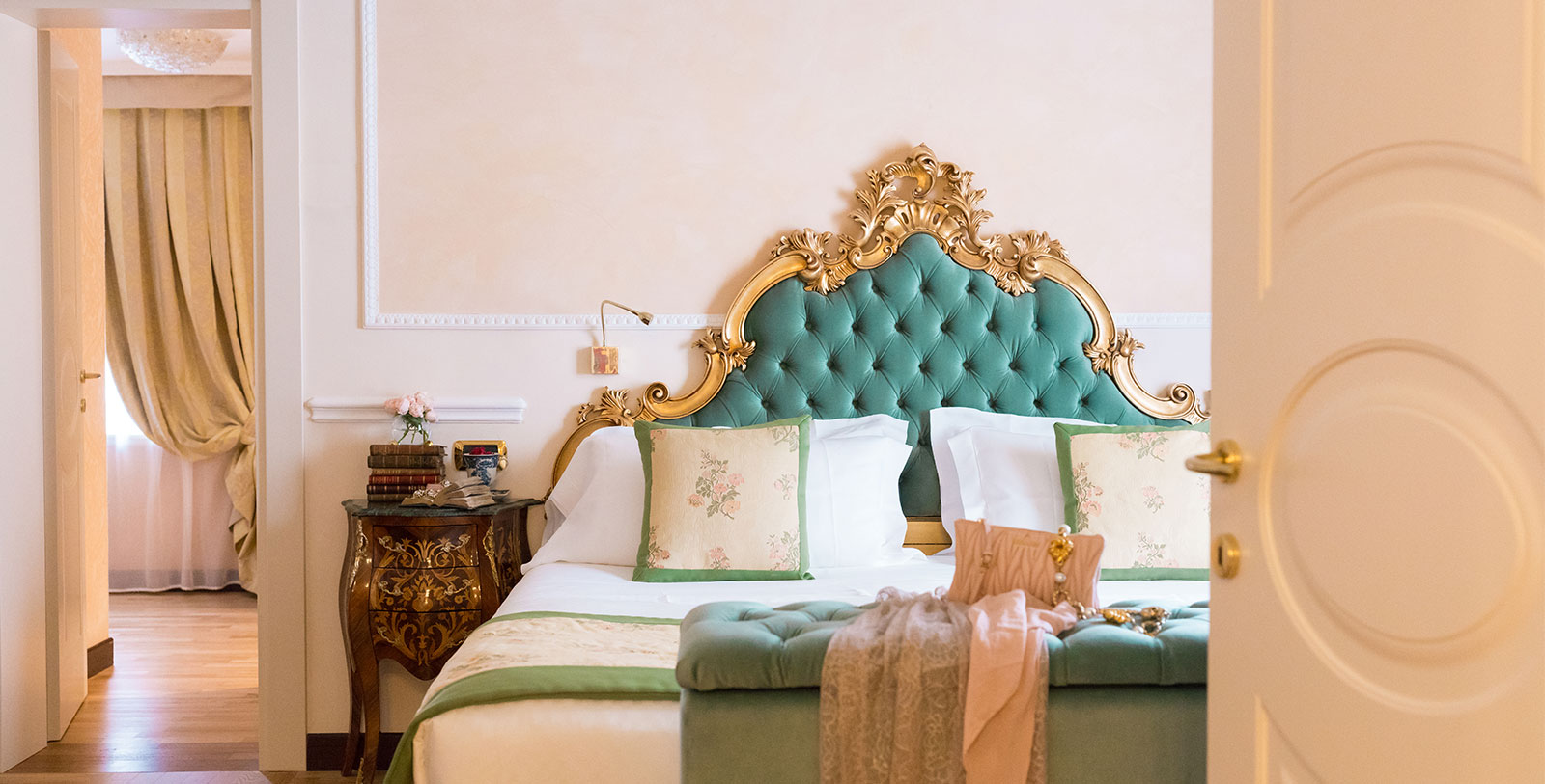 a bed with a green headboard and gold trim