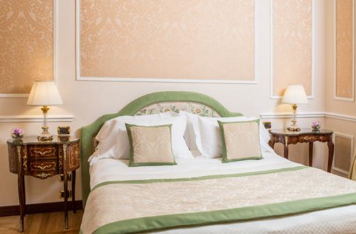 a bed with a green headboard and pillows