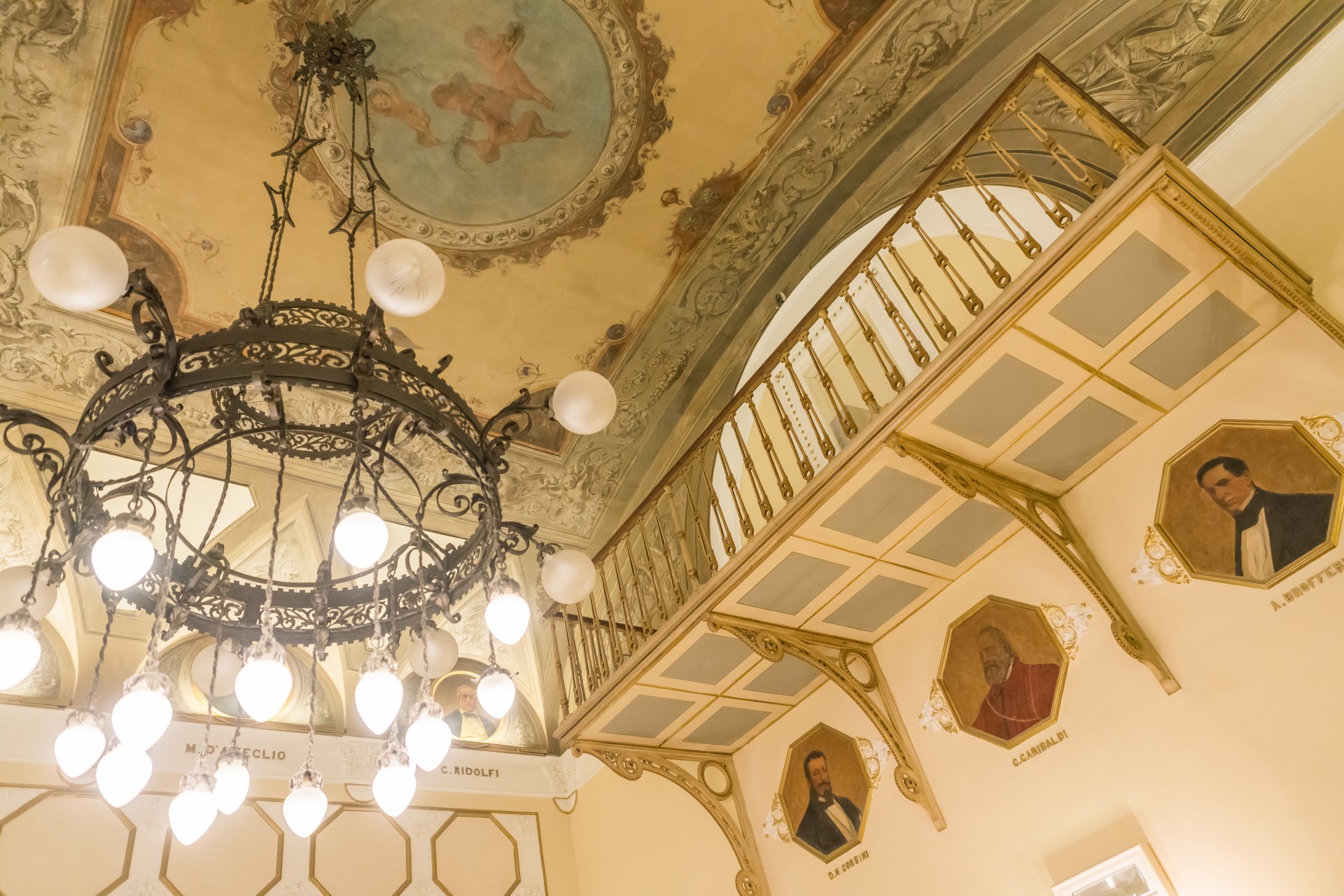 a chandelier in a room with paintings on the ceiling