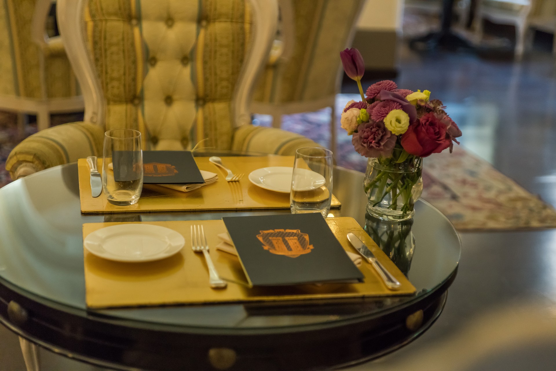 a table with a vase of flowers and menu on it