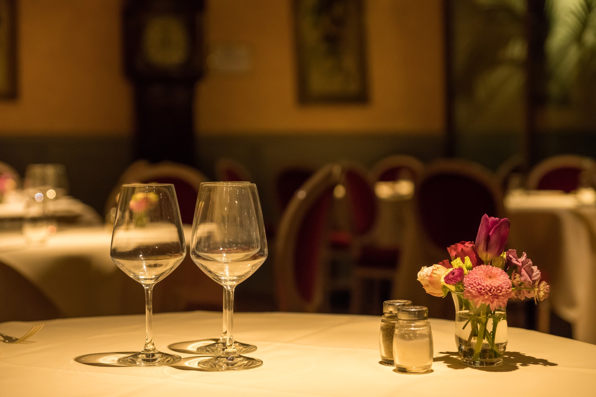 a table with wine glasses and flowers on it