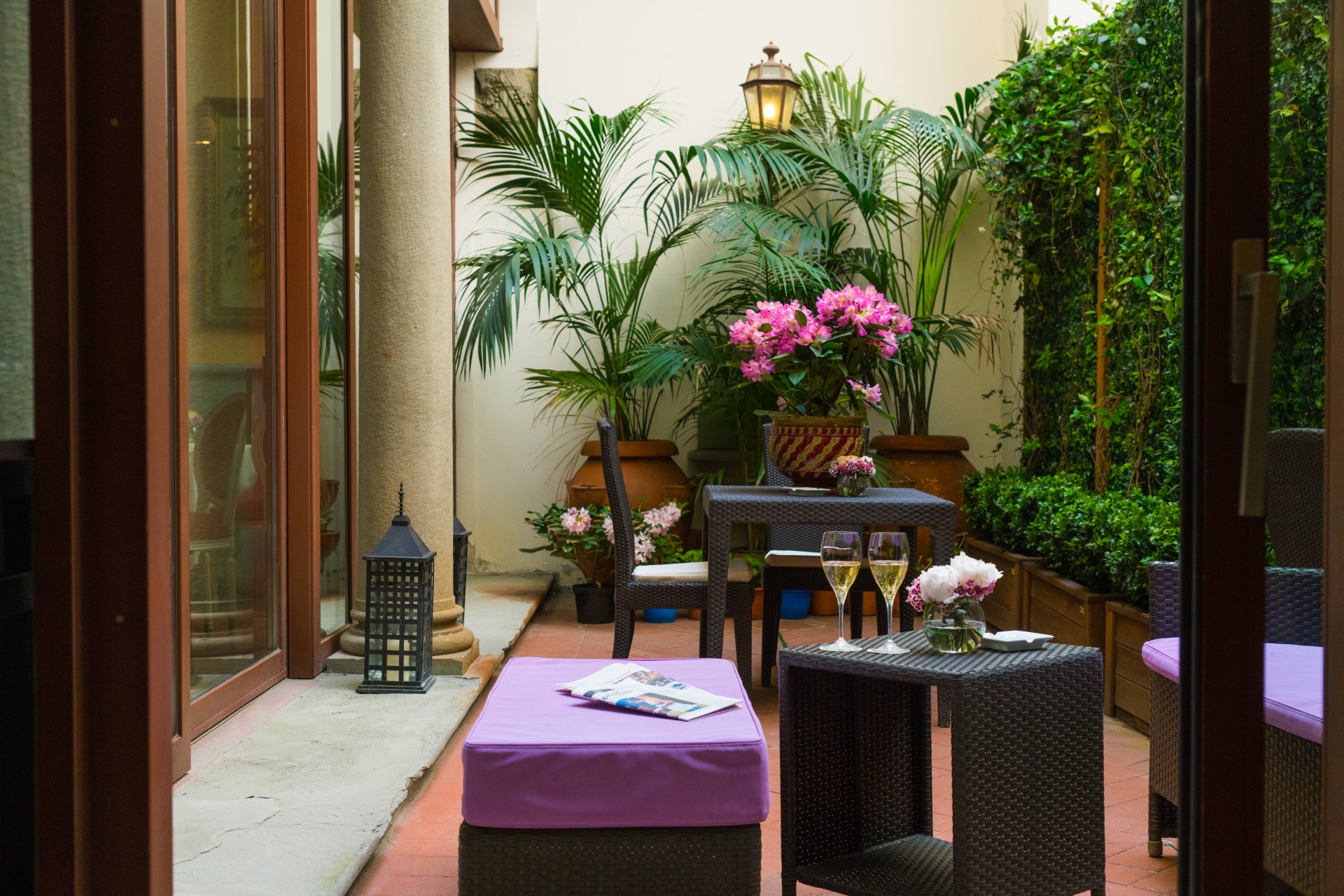 a patio with chairs and tables and flowers