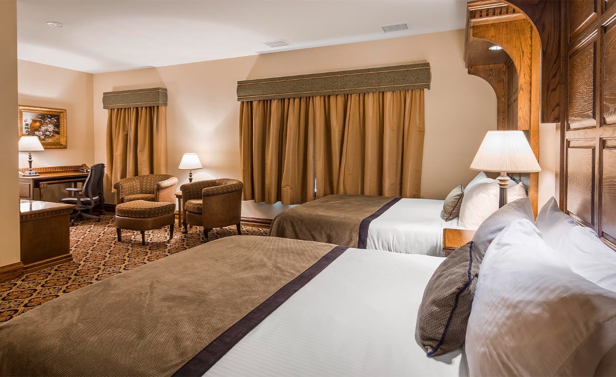 a room with two beds and chairs
